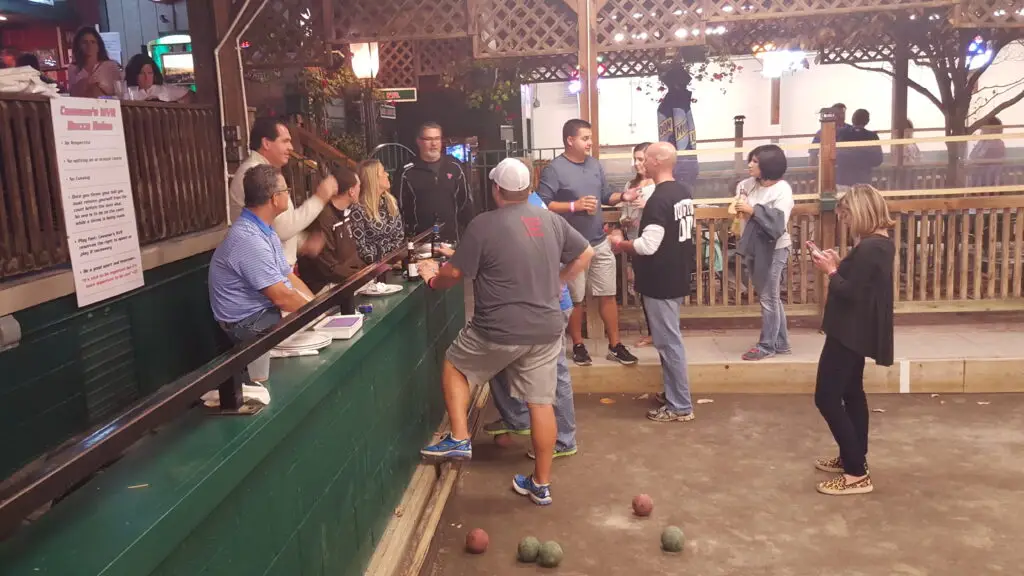 20151012_193515 - Hope Foundation of the Mahoning Valley Group of adults socializing at an outdoor bar while playing bocce; colorful bocce balls scattered on the ground around them.