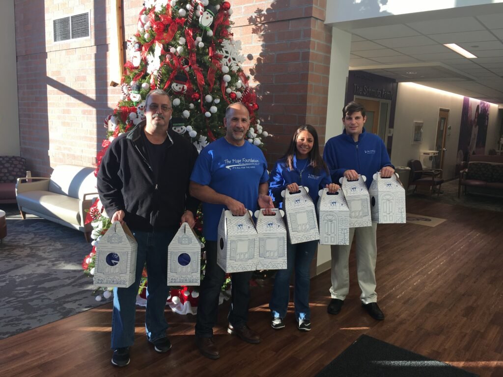 Hope Foundation Members Posing In Front Of A Christmas Tree