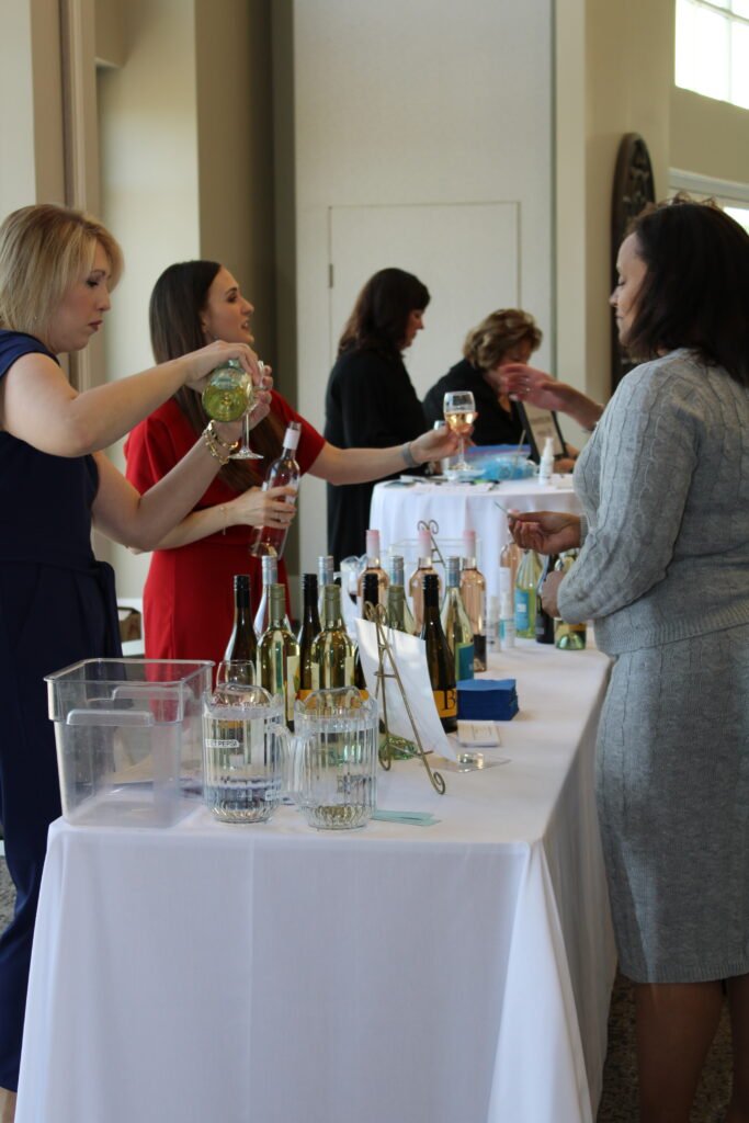 Volunteers pouring wine at a Wine for Hope tasting table